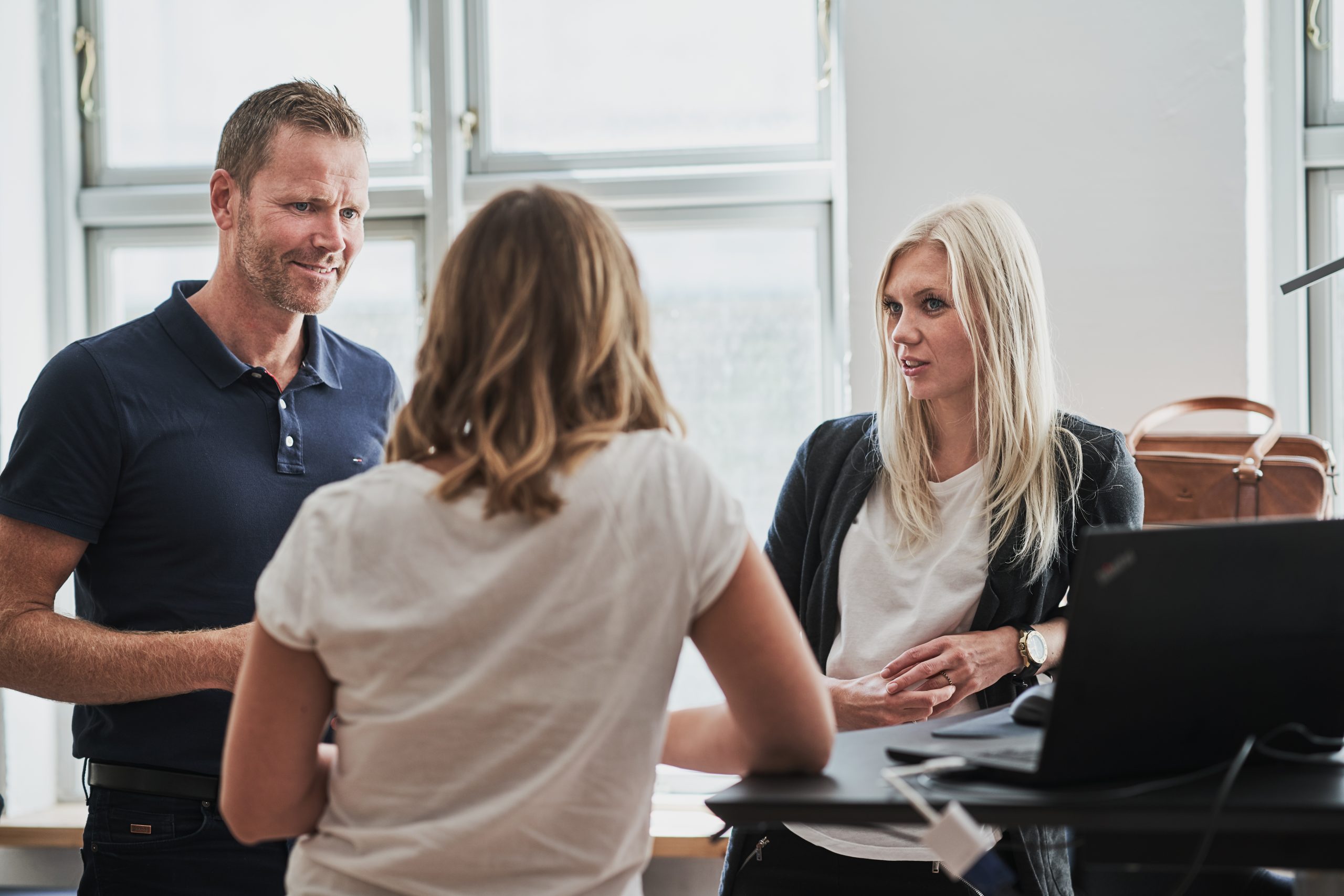 3 mennesker taler sammen på kontor om ledelse og arbejdsmiljø