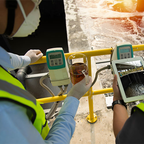 To mænd måler spildevand for PFAS